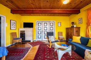 a living room with yellow walls and a blue couch at Ferienwohnung Reet op de Eck in Bargenstedt