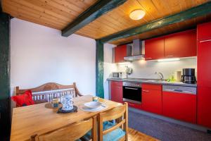 a kitchen with a wooden table and red cabinets at Ferienwohnung Reet op de Eck in Bargenstedt