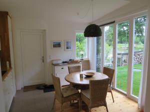 a dining room with a table and chairs and a kitchen at Strandhaus am Oberuckersee in Warnitz