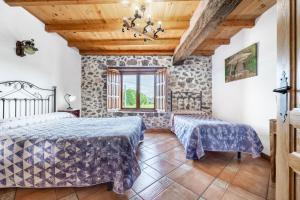a bedroom with two beds and a window at Casa Trasmiera in Solórzano