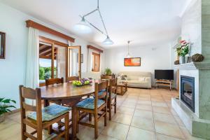 a living room with a table and chairs and a fireplace at Can Mirló in Marratxí 