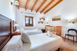 a bedroom with two beds and a crib at Can Mirló in Marratxí  +18 photos