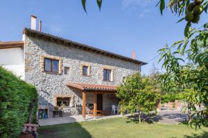 an external view of a stone house with a patio at Casa Trasmiera in Solórzano