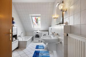 a bathroom with a sink and a washing machine at Ferienwohnung Storchennest in Burg +18 photos