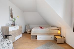 a bedroom with a bed and a dresser in a attic at Ferienwohnung Storchennest in Burg