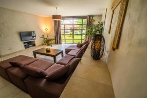 a living room with a brown couch and a table at Le Mas Du Batadou in Visan
