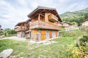 a wooden house with orange doors in a field at Chalet Marmotte in Saint-Martin-de-Belleville