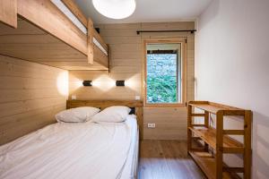 a small bedroom with a bed and a ladder at Chalet Marmotte in Saint-Martin-de-Belleville