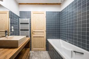 a bathroom with a tub and a sink at Chalet Marmotte in Saint-Martin-de-Belleville +30 photos