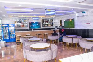 a restaurant with people sitting at tables and a bar at Abiis Hotel and Suites in Abeokuta