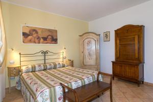 a bedroom with a bed and a wooden dresser at Il Girasole - Limone in Venturina Terme