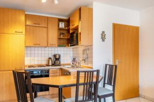 a kitchen with wooden cabinets and a table and chairs at Ferienwohnung Tannenblick 3-2-3-3 in Oberhof