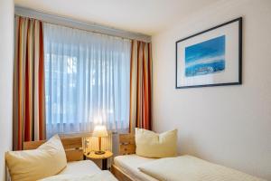 a hotel room with two beds and a window at Ferienwohnung Tannenblick 3-2-3-3 in Oberhof