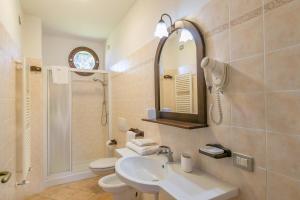 a bathroom with a sink and a toilet and a mirror at Il Girasole - Limone in Venturina Terme