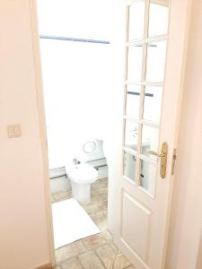 a bathroom with a toilet and a white door at Casa Da Guia in Beja