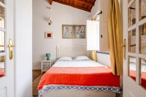 a bedroom with a bed with a red blanket at Casa Da Guia in Beja