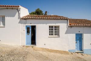 a white house with blue doors at Casa Da Guia in Beja