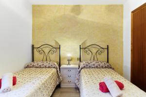 two beds in a bedroom with two red pillows at Casa Arroyo Colmenar in Villanueva del Arzobispo +27 photos