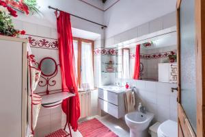 a bathroom with red curtains and a sink and a toilet at Oasi del borgo Montefollonico in Montefollonico +19 photos