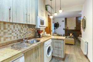 a kitchen with a sink and a washing machine at Casa Arroyo Colmenar in Villanueva del Arzobispo