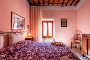 a bedroom with a bed with a purple bedspread at Oasi del borgo Montefollonico in Montefollonico