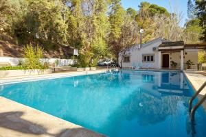a swimming pool in front of a house at Casa Arroyo Colmenar in Villanueva del Arzobispo