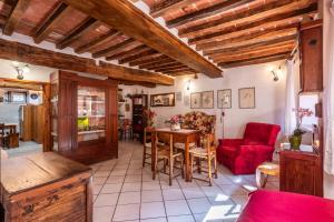 a living room with a table and a red chair at Oasi del borgo Montefollonico in Montefollonico