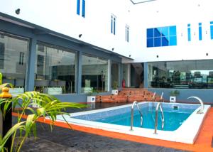 a building with a swimming pool in front of a building at Abiis Hotel and Suites in Abeokuta
