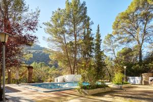 a swimming pool in a yard with trees at Casa Arroyo Colmenar in Villanueva del Arzobispo