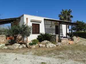 a white house with a palm tree in front of it at Isola Di Favignana in Favignana