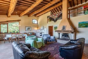 a living room with leather furniture and a fireplace at Agriturismo Paugnano in Radicondoli