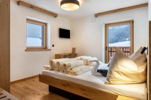 a bedroom with a bed with pillows on it at Planerhof Apartment Enzian in Funes