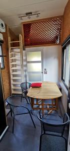 a dining room with a table and chairs in a trailer at La Charmotte in Verbiesles +2 photos