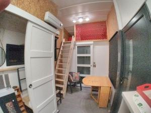 a tiny house with a staircase and a table at La Charmotte in Verbiesles