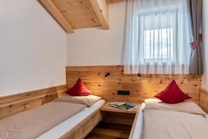 two beds in a small room with a window at Hatzes App Langkofel in Laion