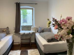 a living room with a couch and a vase of flowers at Ferienwohnung Grete in Münsingen +4 photos