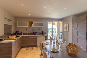 a kitchen with a table and chairs in a kitchen at Logement spacieux agréable in Saint-Privat