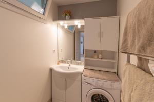 a bathroom with a sink and a washing machine at Logement spacieux agréable in Saint-Privat +13 photos