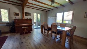a dining room with a table and a piano at Ferienhaus Barbey in St. Blasien