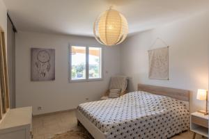 a bedroom with a bed and a window and a chandelier at Logement spacieux agréable in Saint-Privat