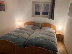 two beds in a bedroom with two lamps on night stands at Ferienhaus Barbey in St. Blasien