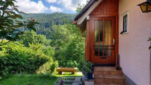 a house with a wooden door and a bench at Ferienhaus Barbey in St. Blasien