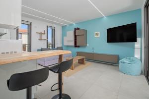 a kitchen with a blue wall and a table and chairs at Pascoli Suite - by And Service in Golfo Aranci