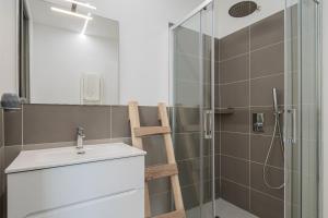 a bathroom with a sink and a glass shower at Pascoli Suite - by And Service in Golfo Aranci +11 photos