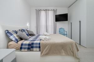 a bedroom with a bed with towels on it at Pascoli Suite - by And Service in Golfo Aranci