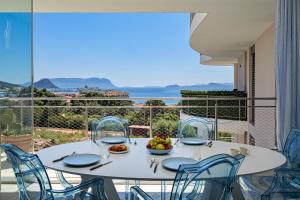 a white table and chairs on a balcony with a view of the ocean at Pascoli Suite - by And Service in Golfo Aranci