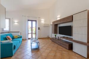 a living room with a blue couch and a television at Summer Spritz in Custonaci