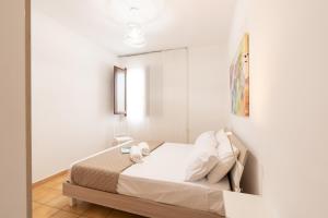a bedroom with a bed with white walls and a mirror at Summer Spritz in Custonaci