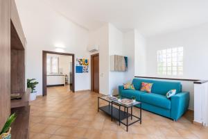 a living room with a blue couch and a table at Summer Spritz in Custonaci