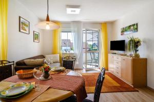 a living room with a dining room table and a television at Relaxen am Illmensee in Illmensee